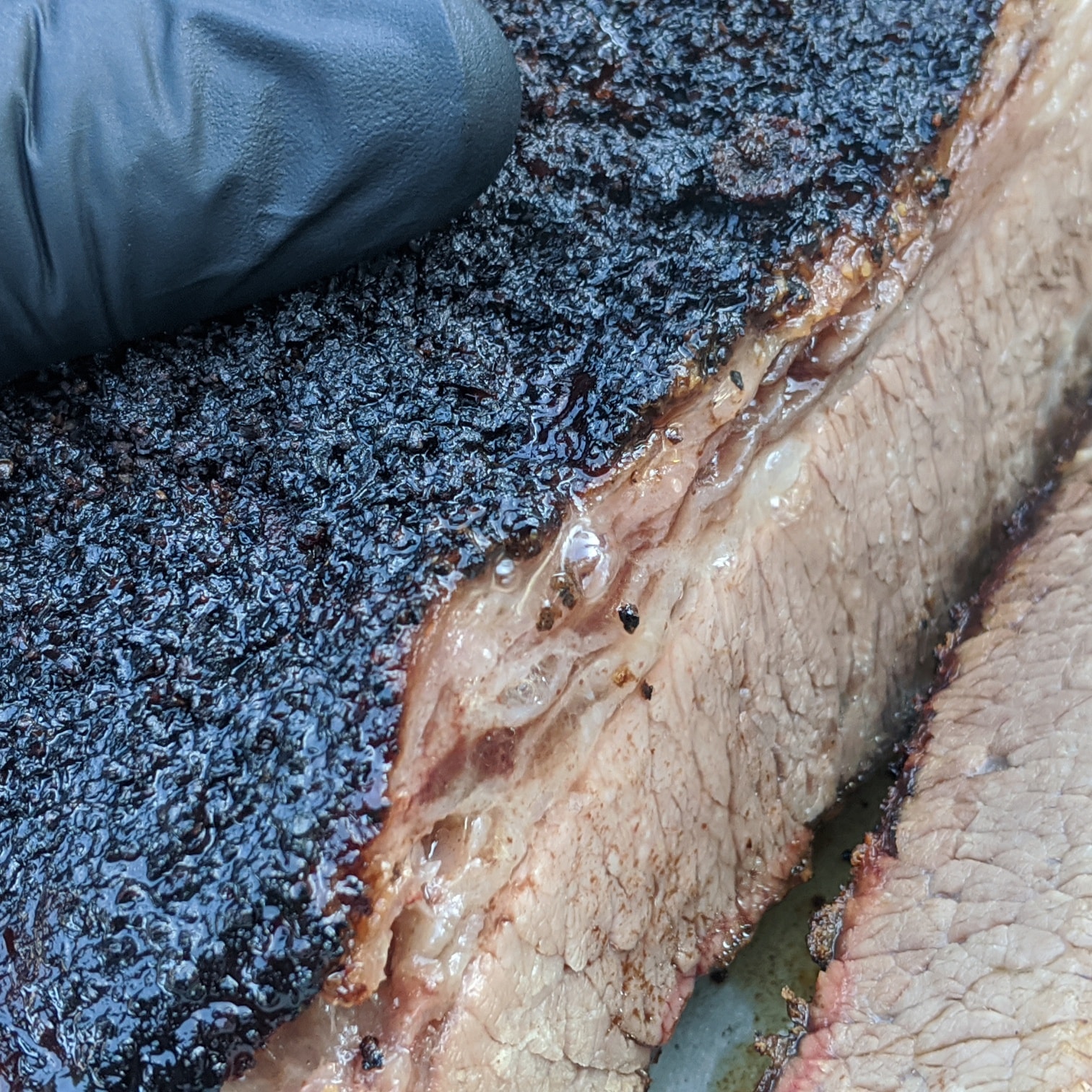Fresh-sliced smoked brisket with a deep bark and rosy smoke ring