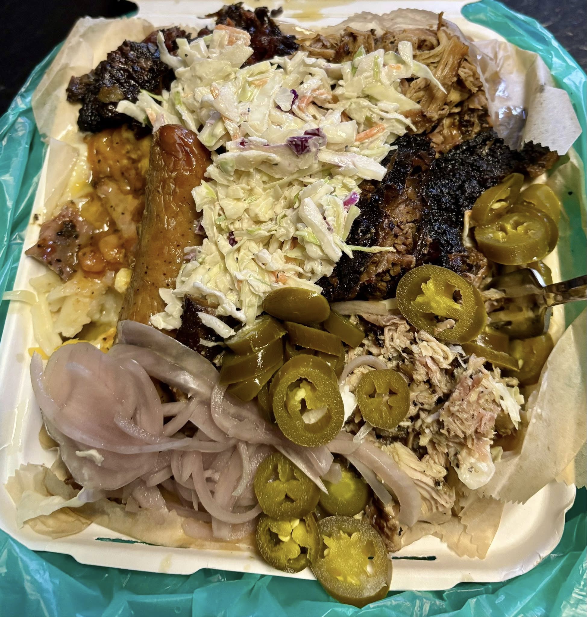 Loaded baked potato topped with smoked meat, melted cheese, and sauce